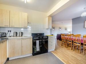 a kitchen with a stove and some wooden cabinets at Heritage Wharf in Mow Cop