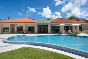 una piscina frente a una casa en Ocean Front Villa Ishigakijima Ⅲ, en Ishigaki Island
