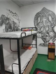 a room with two bunk beds with a painting on the wall at Hostel Taru surf camp and restaurant in Unawatuna
