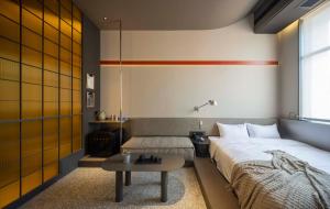 a bedroom with a bed and a table in it at NOA Hotel & Coffee Xiamen in Xiamen
