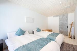 a bedroom with two beds and a window at Ocean Front Villa Ishigakijima Ⅲ in Ishigaki Island +59 photos