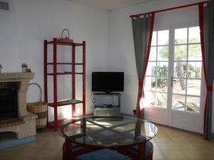 een woonkamer met een tv en een glazen tafel bij Maison La Tranche-sur-Mer, 6 pièces, 8 personnes - FR-1-22-249 in La Tranche-sur-Mer