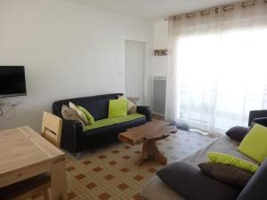 a living room with two couches and a table at Maison confortable près de la plage, au calme, idéale pour des vacances en famille - FR-1-476-101 in La Faute-sur-Mer