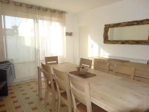 a dining room with a wooden table and chairs at Maison confortable près de la plage, au calme, idéale pour des vacances en famille - FR-1-476-101 in La Faute-sur-Mer +3 photos