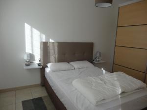 a bedroom with a bed with white sheets and a window at Maison confortable près de la plage, au calme, idéale pour des vacances en famille - FR-1-476-101 in La Faute-sur-Mer