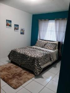 a bedroom with a leopard print bed with a window at Seashells in Nassau