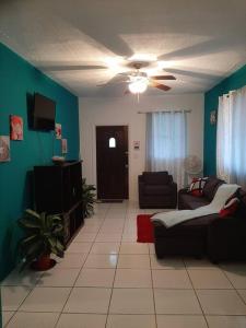 ein Wohnzimmer mit einem Sofa und einem Deckenventilator in der Unterkunft Seashells in Nassau