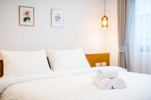 a hotel room with a bed with two towels on it at Portrait Huahin in Hua Hin