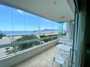 a room with a balcony with a view of the beach at Apartamento com Vista in Balneário Camboriú