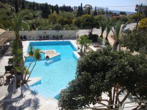 una vista aérea de una piscina con palmeras en Meraki Apartments and Studios, en Tolo