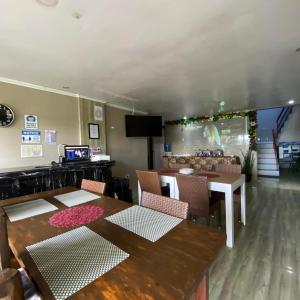 a dining room with a table and chairs and a television at Phuenics de galera in Puerto Galera