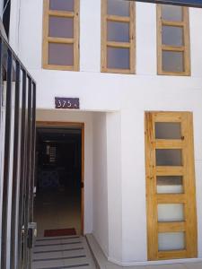 2 fenêtres sur le côté d'un bâtiment avec une porte dans l'établissement Residencial RO, à Copiapó
