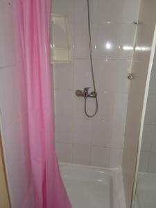 Baño con cortina de ducha rosa junto a la bañera en Residencial RO, en Copiapó