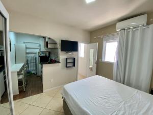 ein Schlafzimmer mit einem Bett und einem Schreibtisch. in der Unterkunft Apartamento Estúdio Vista Mar in Balneário Camboriú
