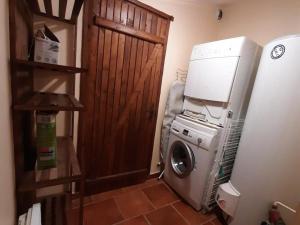 a kitchen with a washing machine and a refrigerator at Gîte Lignières-Ambleville-Lignières-Sonneville, 4 pièces, 11 personnes - FR-1-653-88 in Lignières-Sonneville