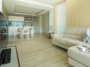 a living room with a couch and a kitchen at The Sea Condominium in Sam Roi Yot