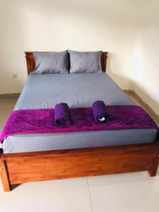 A bed or beds in a room at Calliandra Homestay