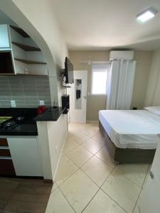 cocina y dormitorio con cama y barra. en Apartamento Estúdio Vista Mar, en Balneário Camboriú