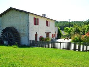 Un edificio blanco con una valla en un patio. en Ancien Moulin Rénové avec Piscine et Jardin, Idéal Familles, Vignobles du Cognac - FR-1-653-88, en Lignières-Sonneville