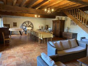 Una sala de estar con un sofá y una mesa con sillas. en Ancien Moulin Rénové avec Piscine et Jardin, Idéal Familles, Vignobles du Cognac - FR-1-653-88, en Lignières-Sonneville