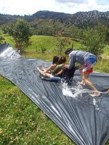a group of people playing on a tarp in a field at Yinkana Camping y Glamping in Guatavita