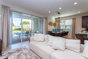 a living room with a white couch and a dining room at Luxurious 5Bd Private Pool Jacuzzi & Game Room at Encore 7432 in Orlando