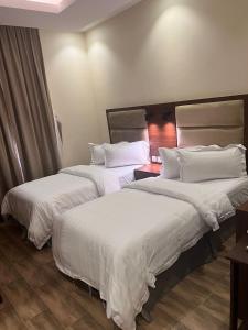 Een bed of bedden in een kamer bij جراند أفيكس 2 للشقق المخدومة - GRAND AFFIX 2