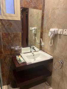 een badkamer met een wastafel en een spiegel bij جراند أفيكس 2 للشقق المخدومة - GRAND AFFIX 2 in Riyad