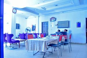 a dining room with a table and chairs and a clock at World Class Hotel & Apartments in Abuja