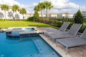 a swimming pool with two lounge chairs and a swimming pool at Luxurious 5Bd Private Pool Jacuzzi & Game Room at Encore 7432 in Orlando