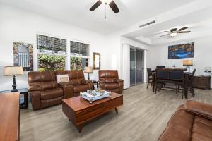 a living room with leather furniture and a table at Kulalani 2003 townhouse in Waikoloa
