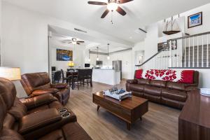 a living room with leather couches and a table at Kulalani 2003 townhouse in Waikoloa
