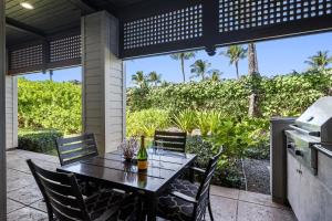 a patio with a table and chairs and a grill at Kulalani 2003 townhouse in Waikoloa