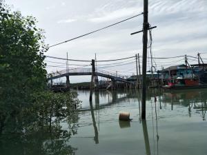 a body of water with a bridge in the background at 吉胆岛海甜民宿 Swee Sea Homestay Pulau Ketam in Bagan Teochew