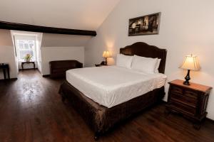 a bedroom with a bed and a chair and a table at Chateau Hotel in New Orleans