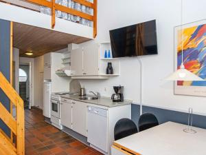 a kitchen with white cabinets and a sink and a table at 6 person holiday home in Fan in Fanø