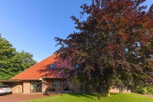 エセンスにあるFerienwohnung Sonnenblumeのオレンジの屋根と木のある家