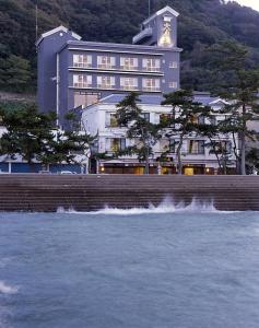 um grande edifício ao lado de uma massa de água em Oishiya em Ise