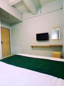 a room with a bed and a flat screen tv at Homestay 81 Batu Batam in Nagoya