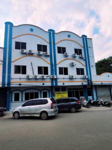 budynek z dwoma samochodami zaparkowanymi przed nim w obiekcie Homestay 81 Batu Batam w mieście Nagoja
