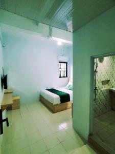 ein Schlafzimmer mit einem Bett und einem Fenster in einem Zimmer in der Unterkunft Homestay 81 Batu Batam in Nagoya