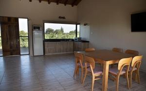 cocina y comedor con mesa de madera y sillas en Casa Premium - Finca Rosablanca, viña y montaña en Vista Flores