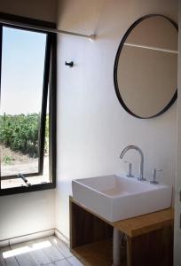 a bathroom with a sink and a mirror at Casa Premium - Finca Rosablanca, viña y montaña in Vista Flores