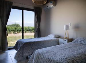 um quarto com 2 camas e uma janela com vista em Casa Premium - Finca Rosablanca, viña y montaña em Vista Flores