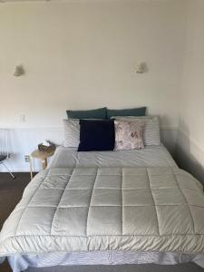 a large bed in a bedroom with a white wall at Cosy Studio on Hyde in Taupo