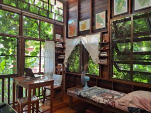 a room with windows and a desk with a laptop at Banban Nannan Library and Guesthome in Nan