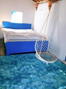 un columpio en una habitación con cama y alfombra en SANTORINI HOME RESORT, en Vạn Ninh