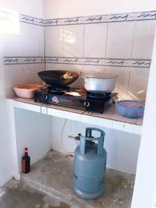 uma cozinha com um fogão e duas panelas e frigideiras em SANTORINI HOME RESORT em Vạn Ninh