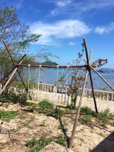 un columpio en la playa cerca del agua en SANTORINI HOME RESORT, en Vạn Ninh