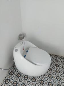 um WC branco numa casa de banho com piso em azulejo em SANTORINI HOME RESORT em Vạn Ninh